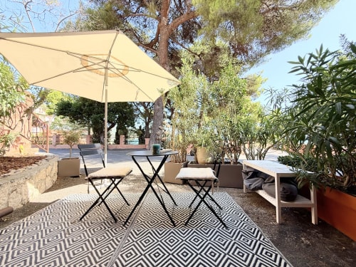 Soleggiata terrazza esterna a La terrazza sul ricetto a Marina di Andora con ombrellone, tavolo, sedie, piante in vaso e