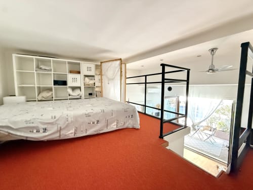 Camera da letto in loft moderno fronte mare a La terrazza sul ricetto con vista sul mare, letto in soppalco, mensole, tappeto rosso e accesso alla terrazza