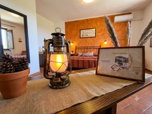 Rustic cottage interior at I Castagnini with vintage lantern, terracotta decor, and warm orange walls in Montecatini Val di