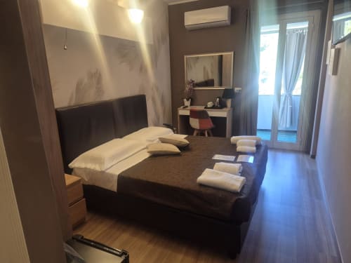 Camera moderna all'hotel Seaside di Sestri Levante con letto scuro, scrivania, balcone e vista sulla città