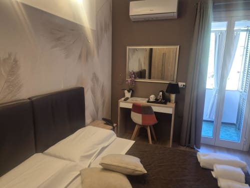 Camera moderna presso l'hotel Seaside a Sestri Levante con letto, scrivania, specchio, condizionatore e accesso al balcone