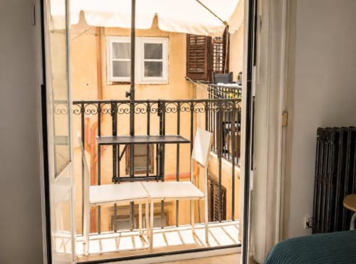 Vista dal balcone della Politeama Central Suite che si affaccia sulla corte interna di Palermo con muri gialli e eleganti ringhiere in ferro battuto