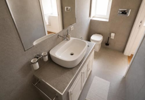 Bagno moderno nella Palermo BnB con lavabo bianco, WC, specchio e finiture in piastrelle neutre