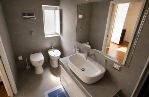 Bagno moderno della Politeama Central Suite a Palermo con toilette, bidet, lavabo, specchio e finestra