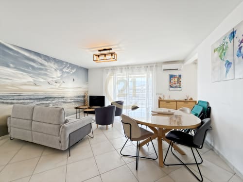 Appartement T3 moderne à Calvi avec vue mer, séjour, salle à manger, canapé et terrasse aménagée sur l'océan