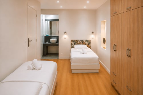 Modern twin bedroom at Enjoy Nice Rossetti apartment, featuring wooden floors, en-suite bathroom, and contemporary