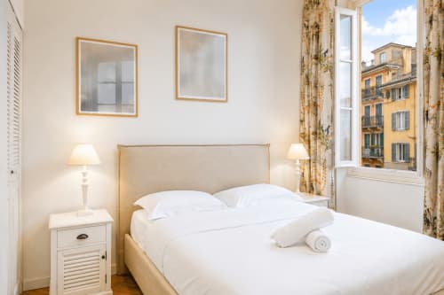 Elegant bedroom at Enjoy Nice hotel in Nice with view of Rossetti landmark, white bedding, and classical décor
