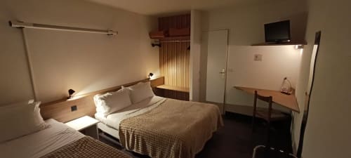 Hotel Du Rocher room in Le Caylar with double bed, TV, desk, and modern amenities