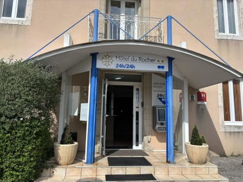 Entrée de l'Hôtel du Rocher au Caylar avec auvent en acier bleu et réception 24h/24