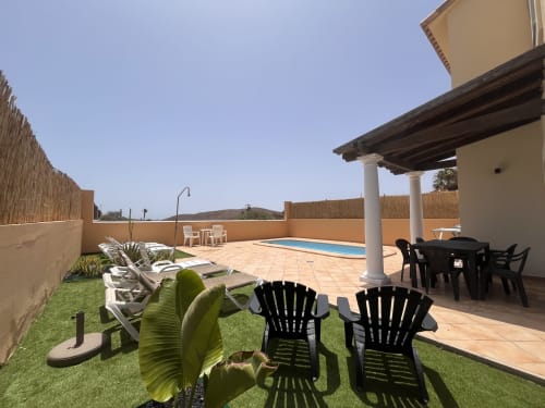 Casa Reguera villa terrace with pool, loungers, dining area, and sea views in Geafond
