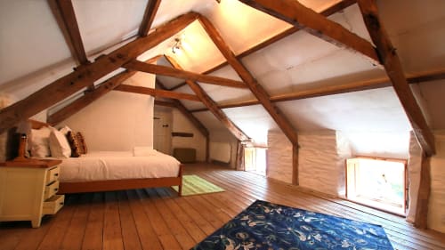 Spacious attic bedroom in Llwyncadfor villa, Llandysul, with wooden beams, bed, hardwood floors and skylights