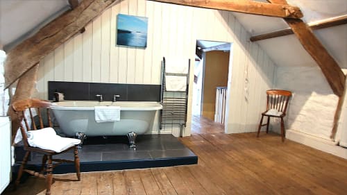 Spacious loft-style bathroom at Llwyncadfor villa with freestanding bath, wooden beams, wooden flooring, and modern amenities