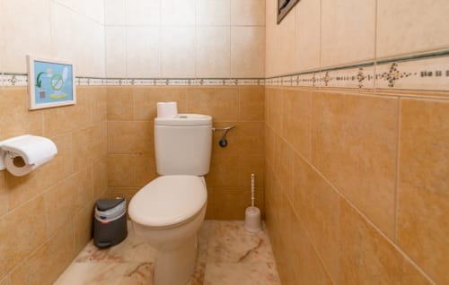 Bathroom in Casa Reguera villa at FTV Holidays Homes, Geafond, with beige tiled walls and white toilet