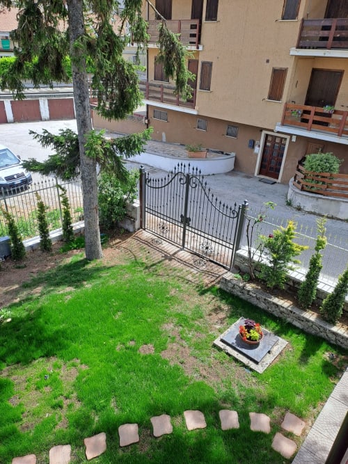 Giardino della villa di Ovindoli con sentiero in pietra, fioriera fiorita, cancello della terrazza e architettura alpina