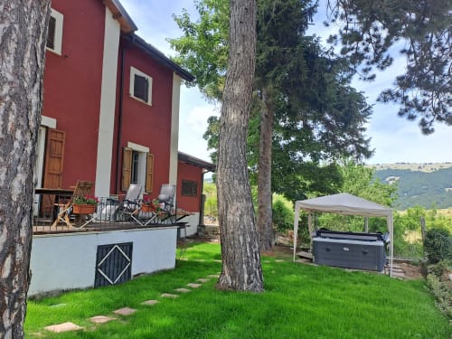 Villa bianca e rossa con vista montagna, terrazza con sdraio e gazebo con grill a Ovindoli
