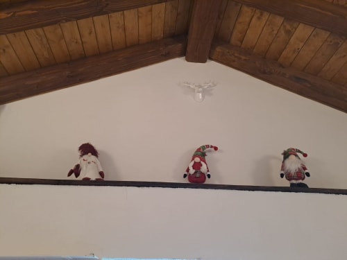 Tre gnomi di Babbo Natale decorativi esposti su una trave di legno nello Chalet Maxi Momosa dell'Antico Chalet Momosa, Ovindoli, IT
