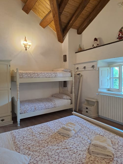 Camera rustica dell'Antico Chalet Momosa a Ovindoli con letti a castello, travi in legno e vista montagna