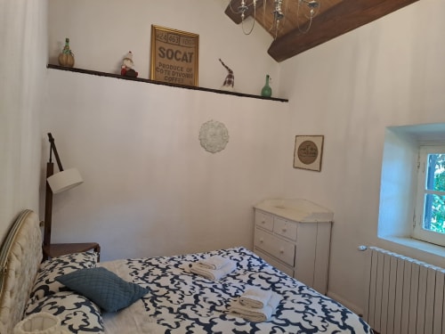 Camera accogliente nella villa Antico Chalet Momosa con biancheria decorata, travi in legno rustico e arredamento vintage