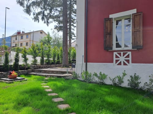 Villa Chalet Maxi Momosa rosso e bianca a Ovindoli con prato curato, vialetto in pietra e vista sulle montagne