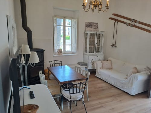 Accogliente soggiorno dell'Antico Chalet Momosa con tavolo da pranzo, camino e vista sulle montagne a Ovindoli