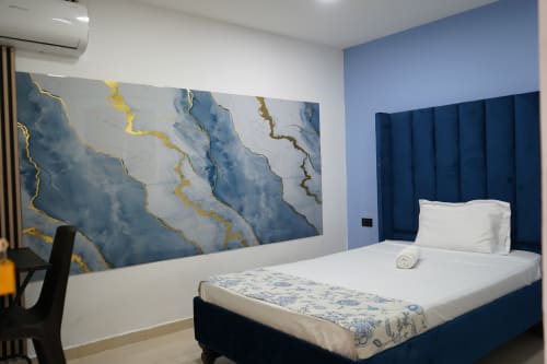Dormitorio moderno de Casa Mango Cali con cabecero tapizado en azul, ropa de cama blanca y obra de arte abstracta en mármol azul