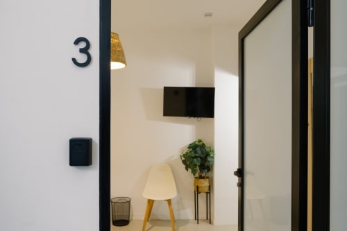 Entrada de la Habitación 3 del hotel Stay Gest Valencia con televisor, sillón, planta decorativa y mobiliario moderno