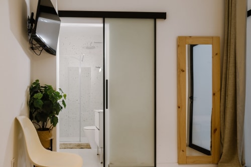 Baño moderno con ducha amplia, inodoro y puertas corredizas de cristal en el hotel Stay Gest de Valencia, España