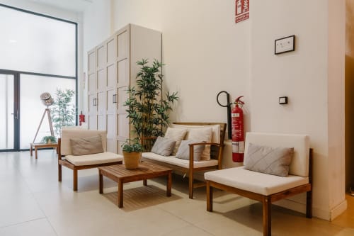 Moderna sala de descanso en Stay Gest Valencia con muebles de madera, plantas y equipo de seguridad contra incendios