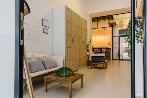 Habitación moderna del hotel Stay Gest Valencia con armario de madera, sofá, planta decorativa e iluminación ambiental