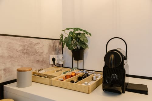 Escritorio accesible en habitación del Stay Gest Valencia con organizador de madera, planta en maceta, cafetera y auriculares