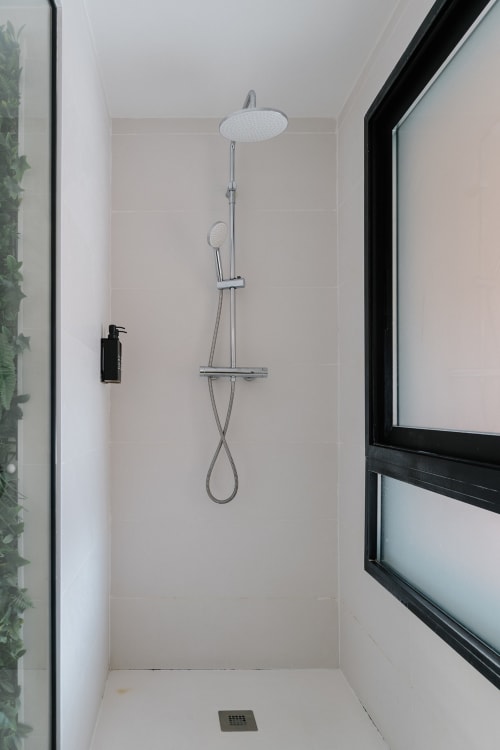 Moderno baño con ducha de lluvia doble y alcachofa de mano en el hotel Stay Gest de Valencia