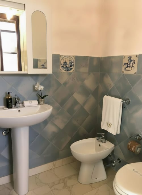 Elegante bagno dell'Hotel Candalù con piastrelle geometriche, lavabo su colonna, bidet e piastrelle decorative del BnB Valderice