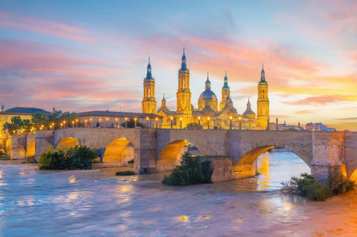 Basilica del Pilar and stone bridge over Ebro River at sunset in Zaragoza, Spain