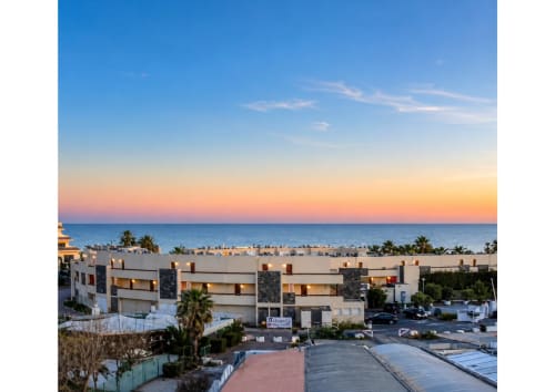 Vue coucher de soleil sur la Méditerranée depuis les appartements Agde Luxury Loc avec palmiers et architecture moderne, Village naturiste