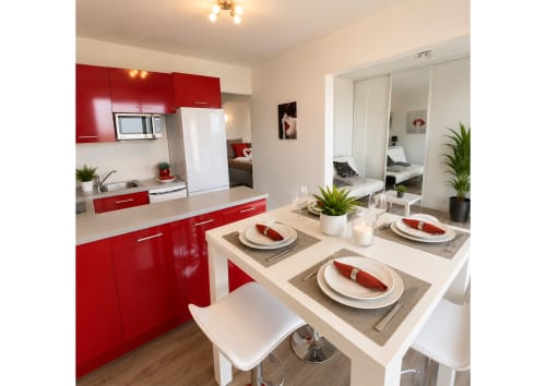 Cuisine moderne rouge et blanc avec coin repas dans un appartement de luxe à Agde, accès vue mer et équipement complet