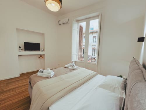 Camera moderna all'Hotel Candalù di Valderice con letti gemelli, nicchia TV integrata e balcone con vista sui palazzi del paese