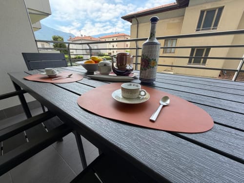 Terrazza esterna della Holiday Home Garda Trentino ad Arco con tavolo da pranzo, area caffè e vista sulle montagne