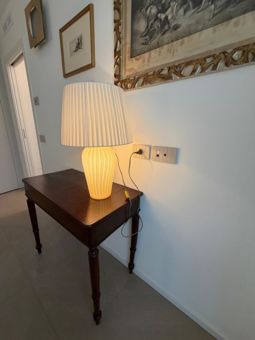 Elegante tavolino in legno scuro con lampada plissettata illuminata nell'appartamento La Carezza, Holiday Home Garda Trentino, Arco