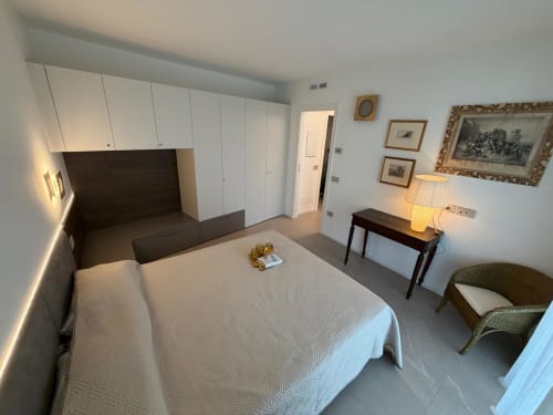 Camera da letto moderna a Holiday Home Garda Trentino ad Arco con letto, armadio, scrivania e vista sul giardino