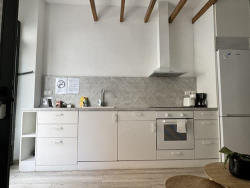Cocina blanca moderna con encimera gris en apartamento madrileño de Artbel Rentals