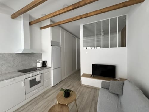 Moderno apartamento en Madrid con cocina, sala de estar, vigas vistas, TV y cómodos muebles en Artbel Rentals