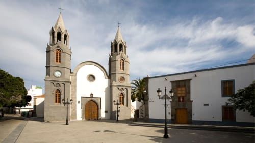 Iglesia histórica blanca con torres campanario gemelas en plaza de Telde, arquitectura colonial Hotel Cortijo San Ignacio