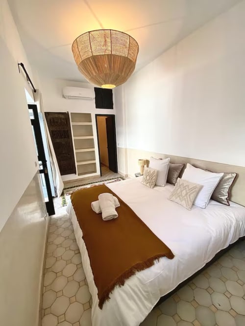 Riad 191 bedroom in Marrakech featuring queen bed, woven ceiling lamp, and traditional tilework