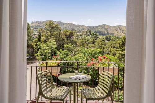 Vista dal balcone dell'appartamento Dimora Silva a San Martino delle Scale con paesaggio montano, sedie verdi e fiori