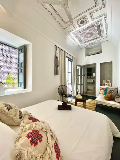 Chambre du Riad 191 à Marrakech avec plafond ouvragé, fenêtre sur patio et mobilier contemporain