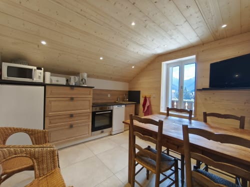 Cucina-soggiorno dell'appartamento Chalet Coste Belle con arredi in legno, vista montagna e comfort moderni a Ceillac