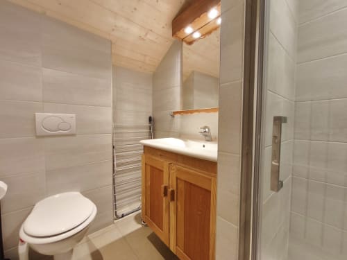 Bagno moderno nell'appartamento Chalet Coste Belle con mobiletto in legno, scaldasalviette e box doccia in vetro