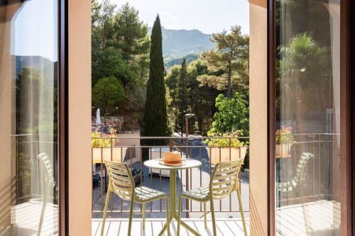 Balcone di Dimora Silva Nature Suites con sedie gialle, tavolo rotondo e vista panoramica su San Martino delle Scale