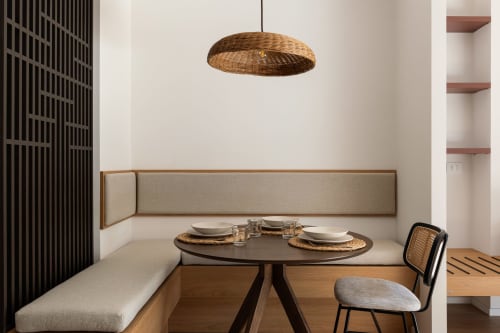Elegante zona pranzo presso Dimora Silva Nature Suites con lampada sospesa intrecciata, panchina integrata e tavolo rotondo a San