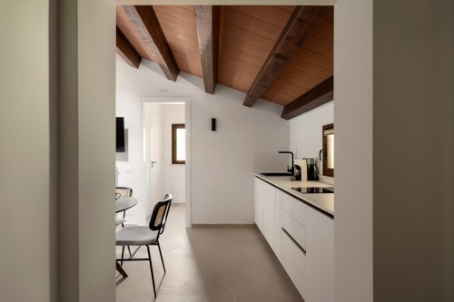 Cucina moderna con cabinetry bianco, travi in legno a vista e zona pranzo a Dimora Silva Nature Suites, San Martino delle Scale
